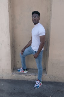 A confident man in casual denim against a luxury café backdrop.