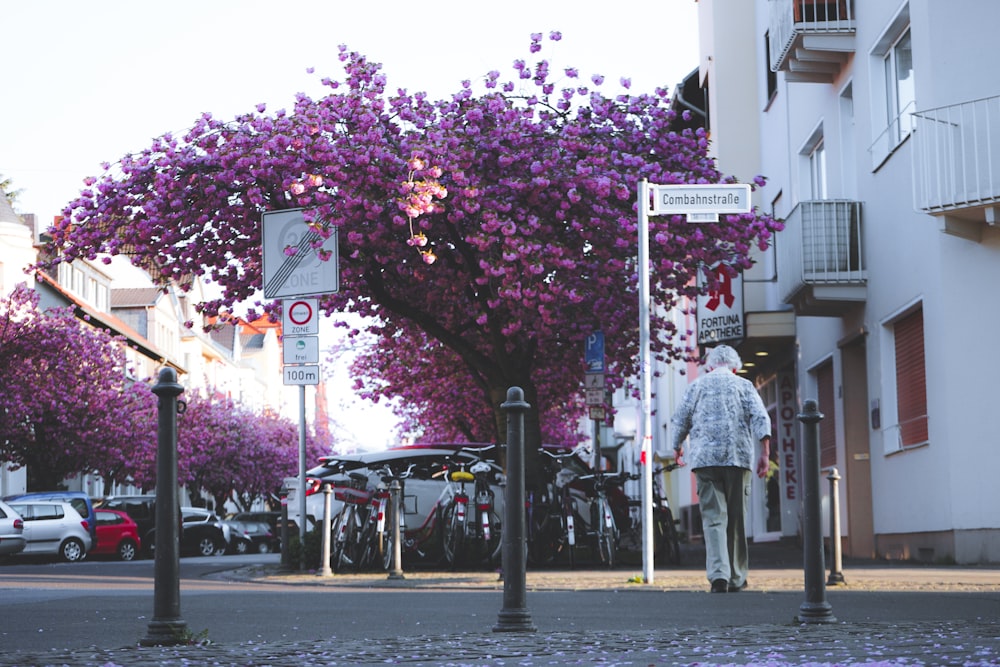 woman in white and blue dress standing on sidewalk near city buildings during daytime