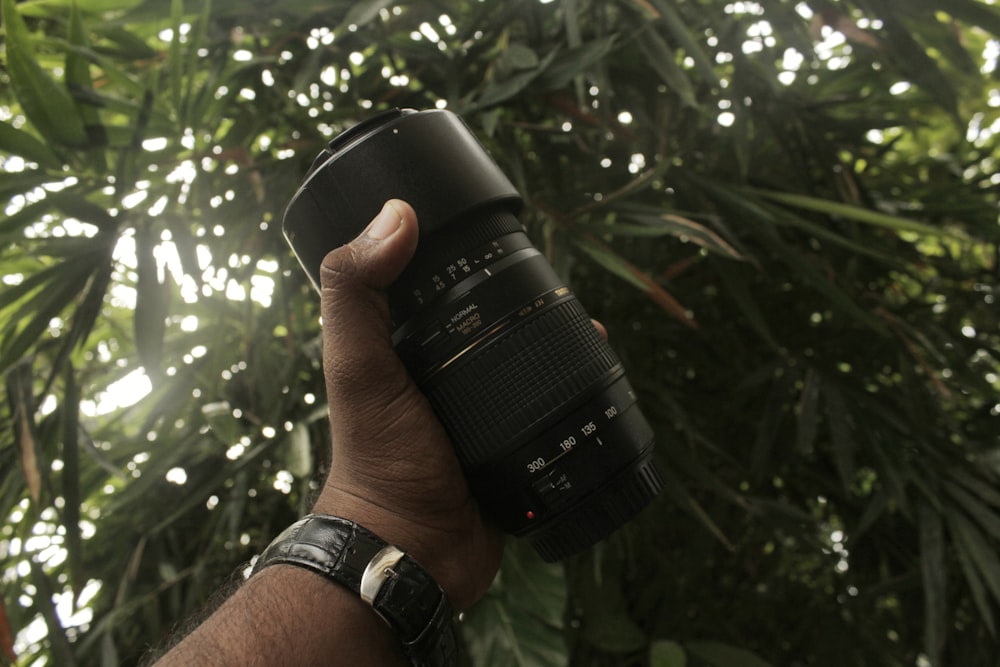 person holding black camera lens