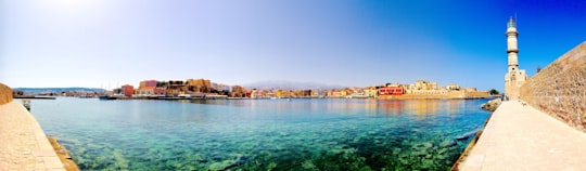 body of water near city buildings during daytime in Old Venetian Harbour Greece