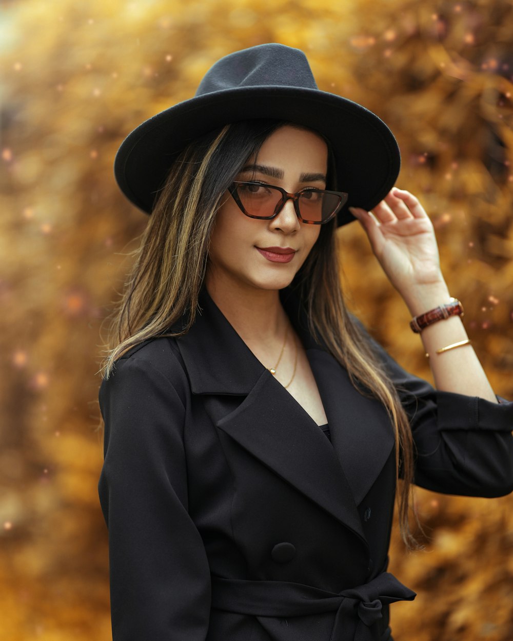 woman in black coat wearing black hat and black sunglasses