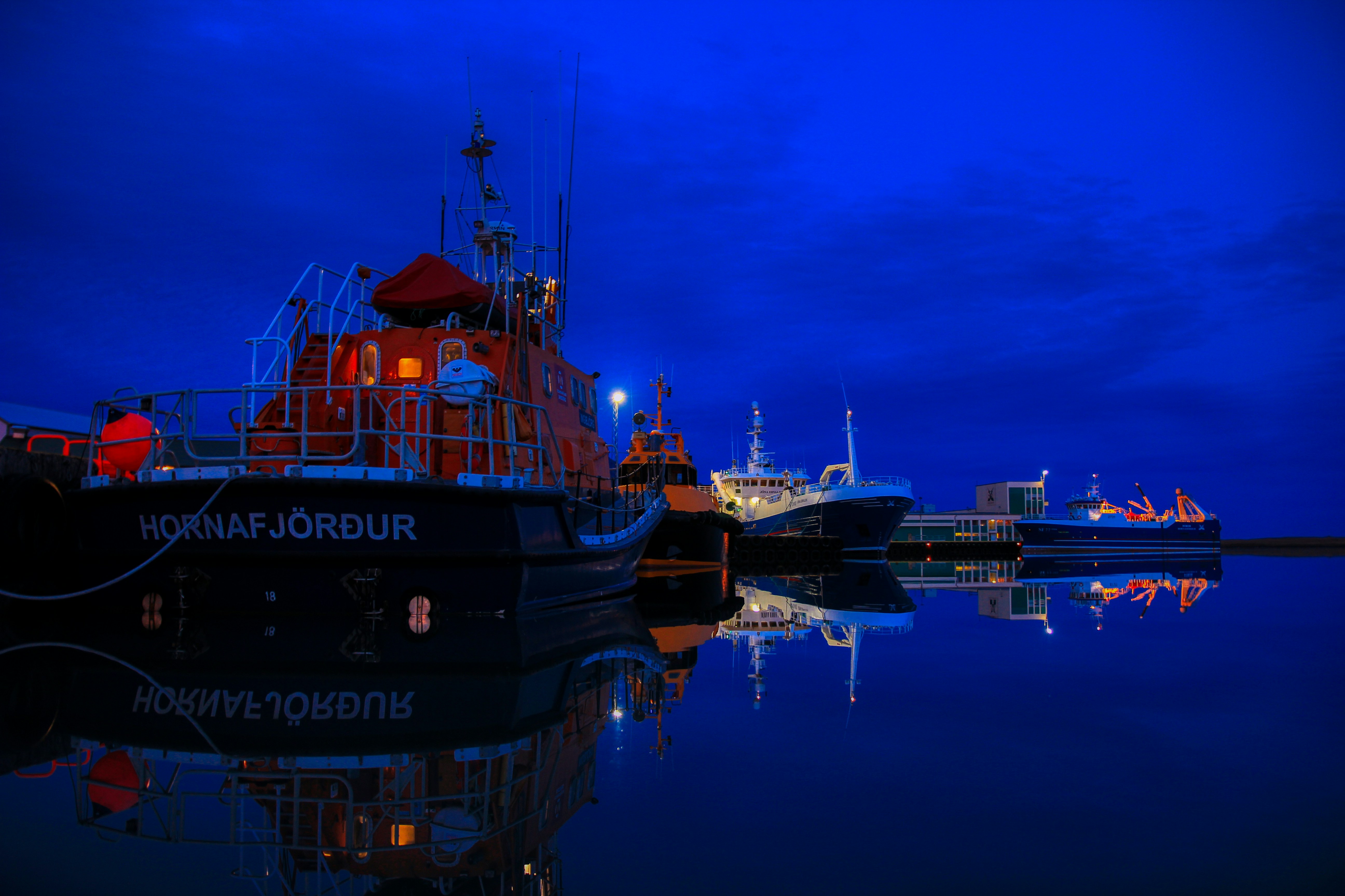 black and orange ship on water during sunset