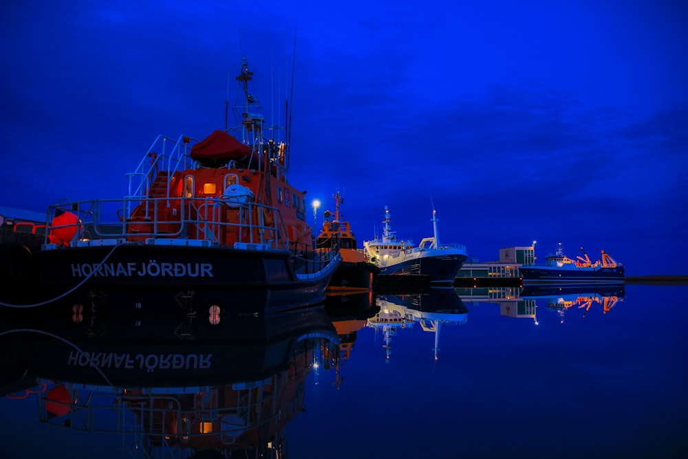 black and orange ship on water during sunset