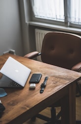 silver macbook on brown wooden table