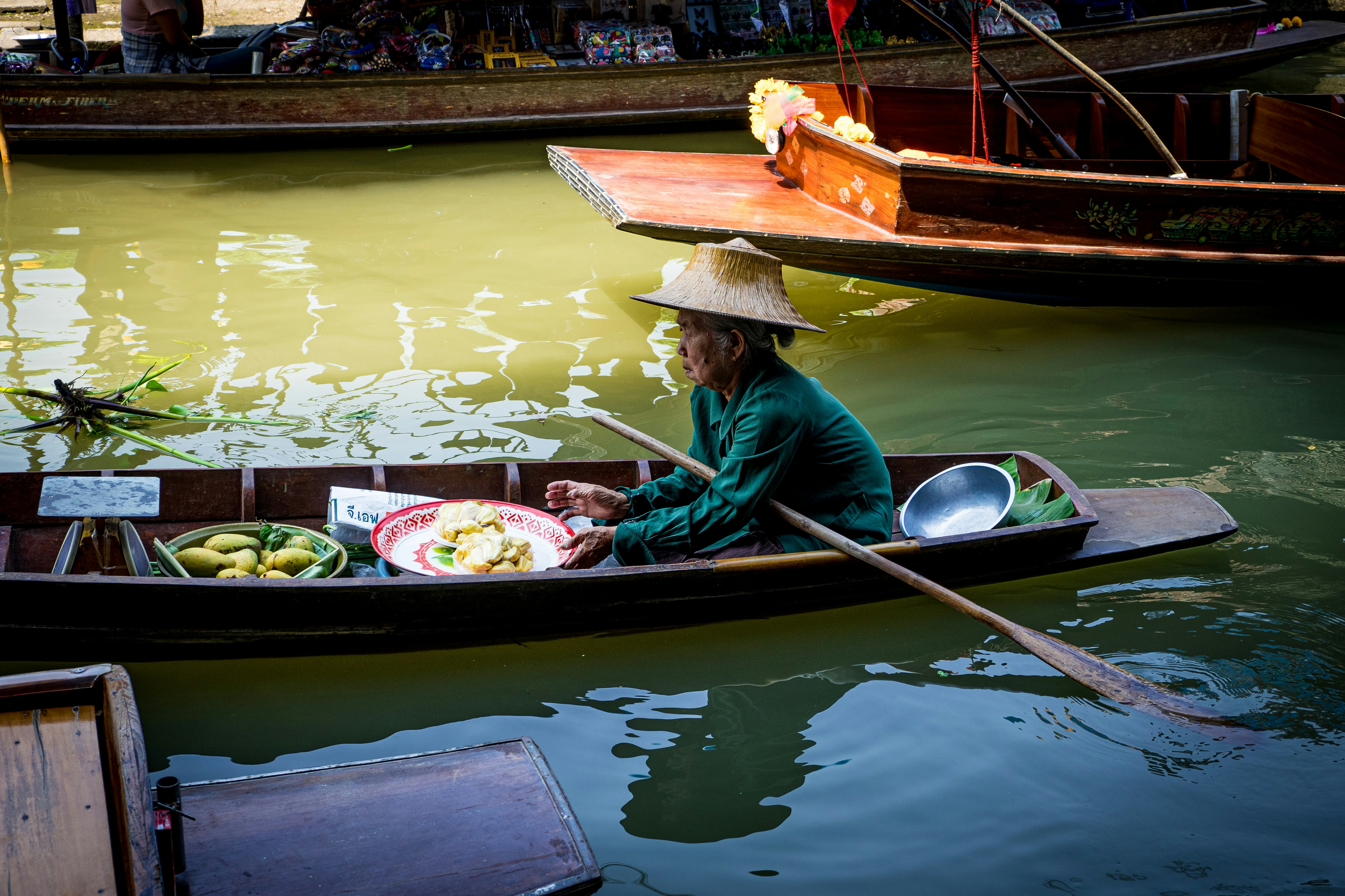 woman in red jacket riding on brown boat during daytime