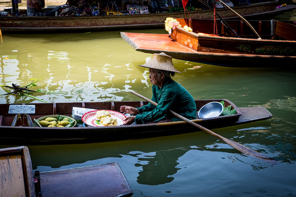 woman in red jacket riding on brown boat during daytime