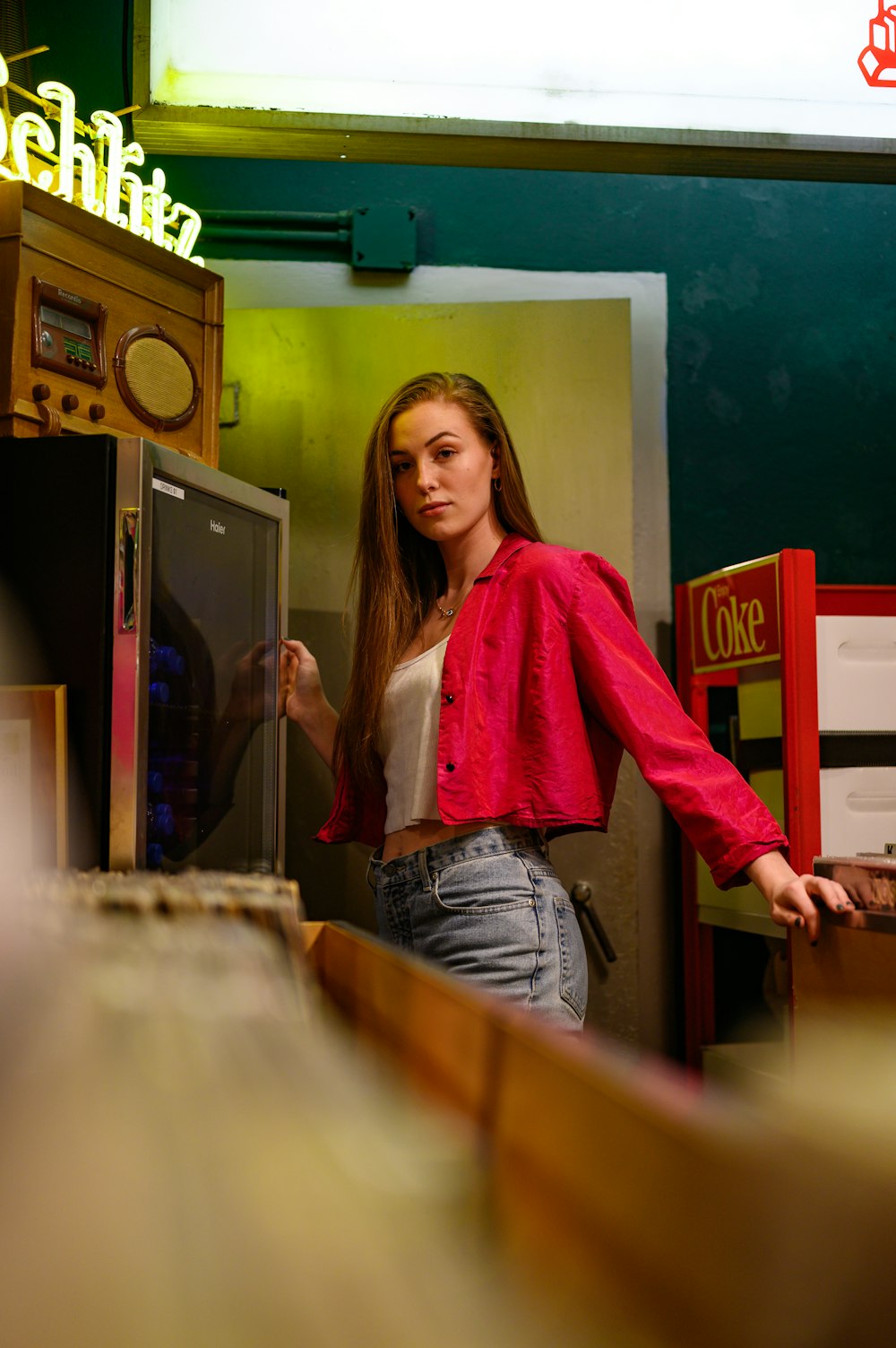 woman in pink cardigan standing beside brown wooden table