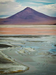 Colorful high-altitude lagoons with flamingos and rugged mountains in the background.