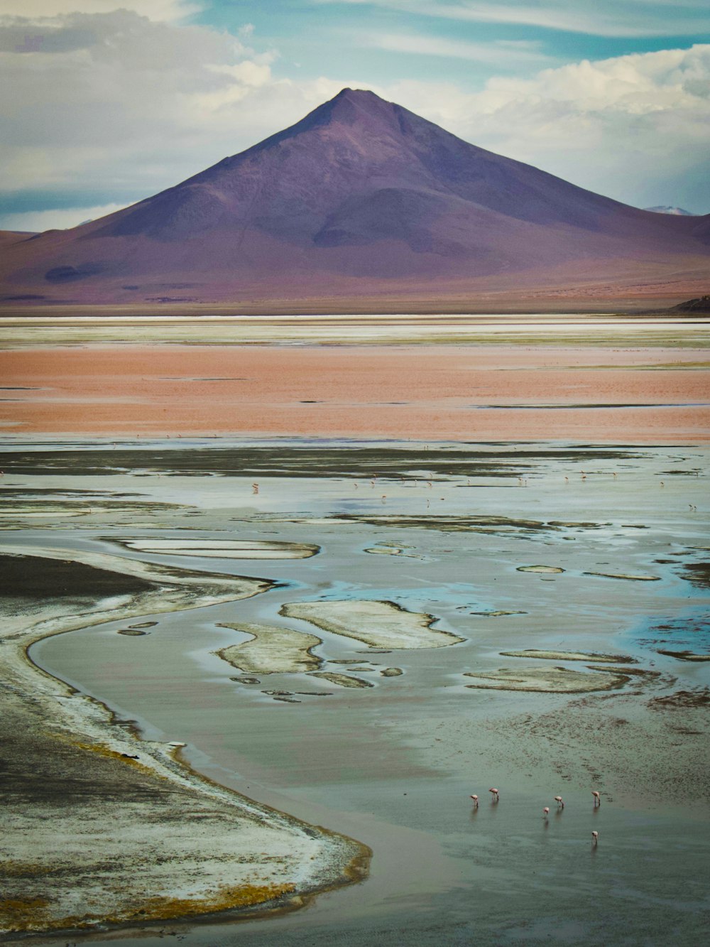 brown and white mountain near body of water during daytime