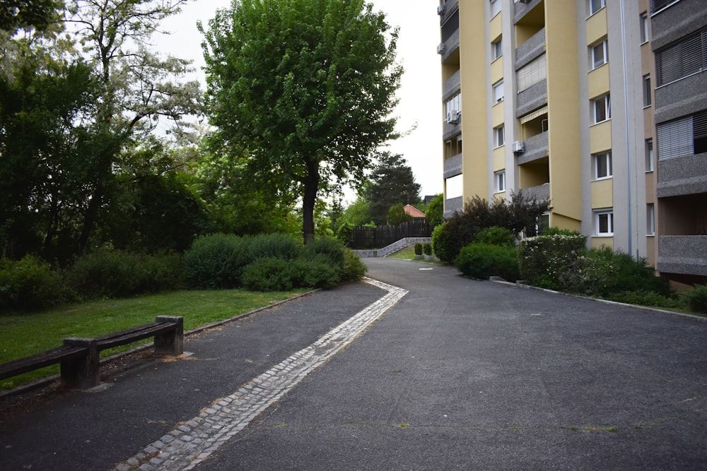 an empty street with a bench in the middle of it