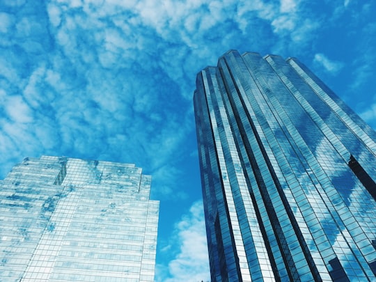 low angle photography of high rise building under blue sky during daytime in Edmonton Canada