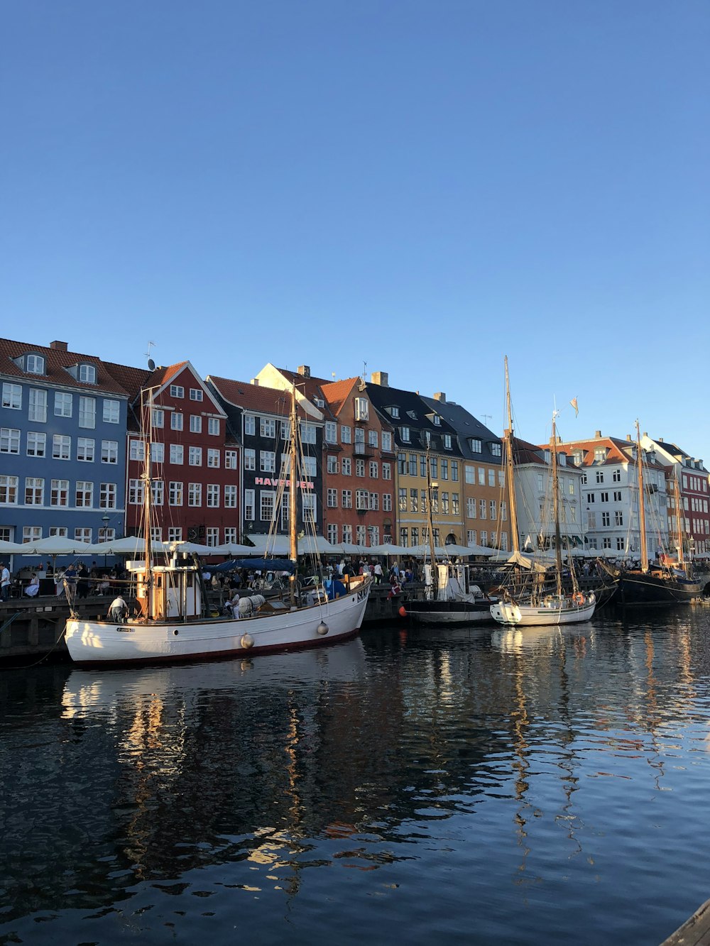 white boat on body of water near buildings during daytime