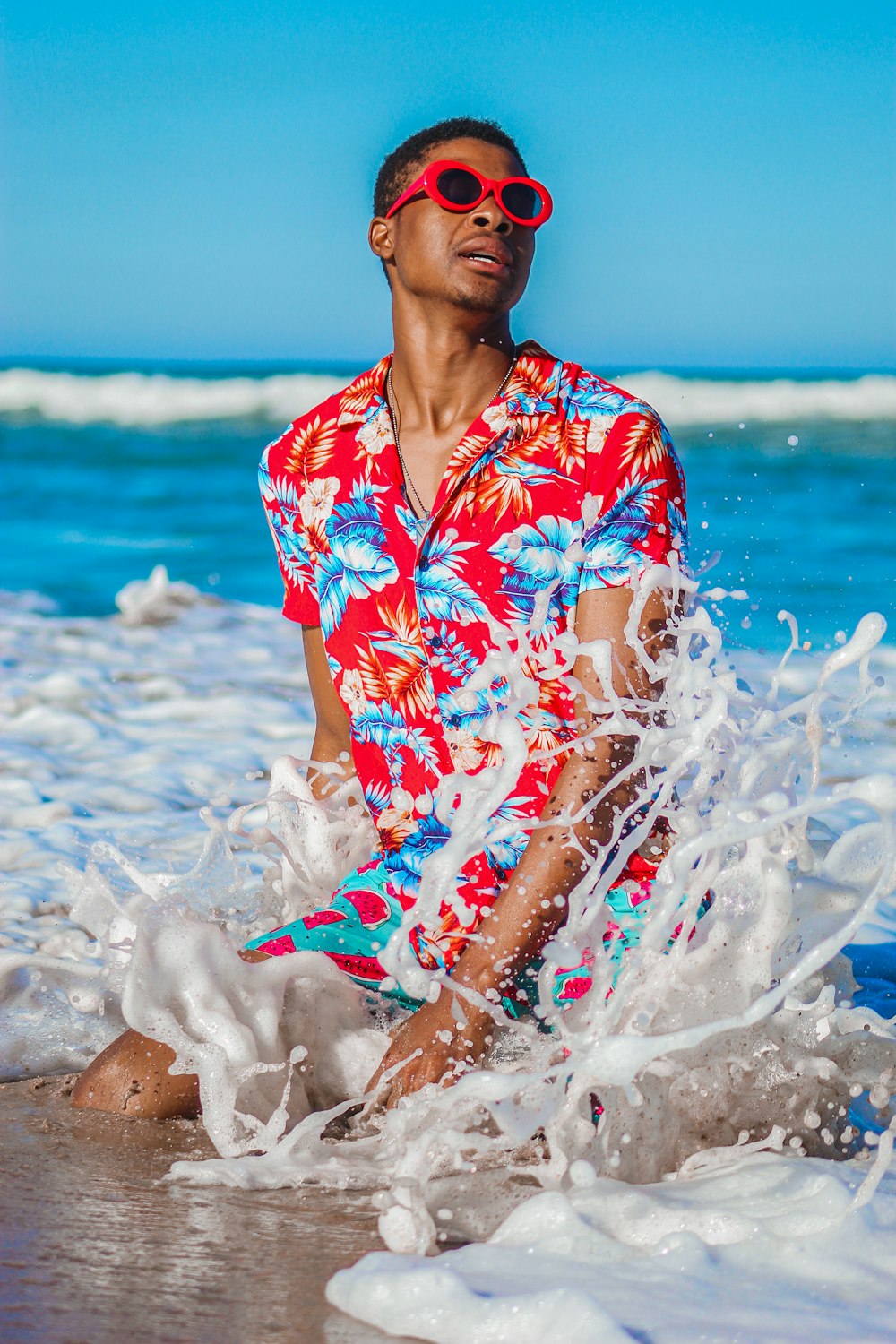 woman in red white and blue floral shirt on beach during daytime