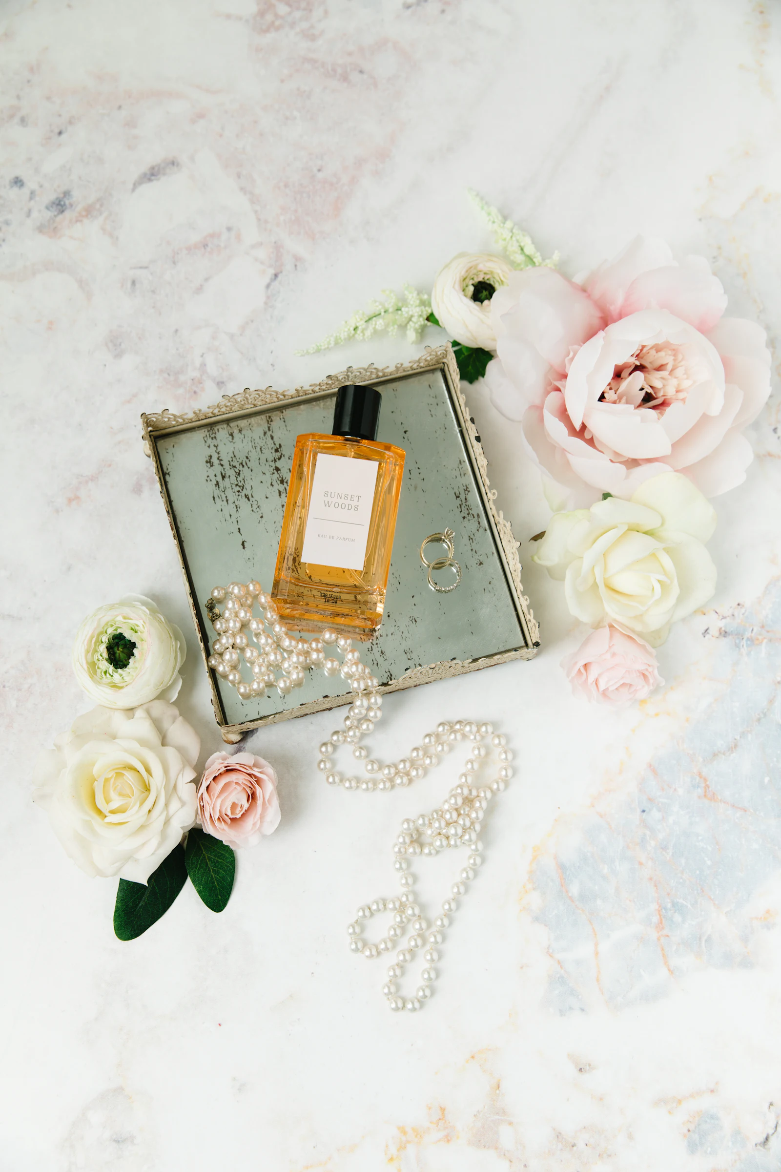 Flacon de parfum doré sur un tissu fleuri