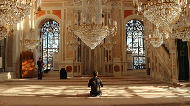 A man praying in a mosque for a blog on time management for Muslims.