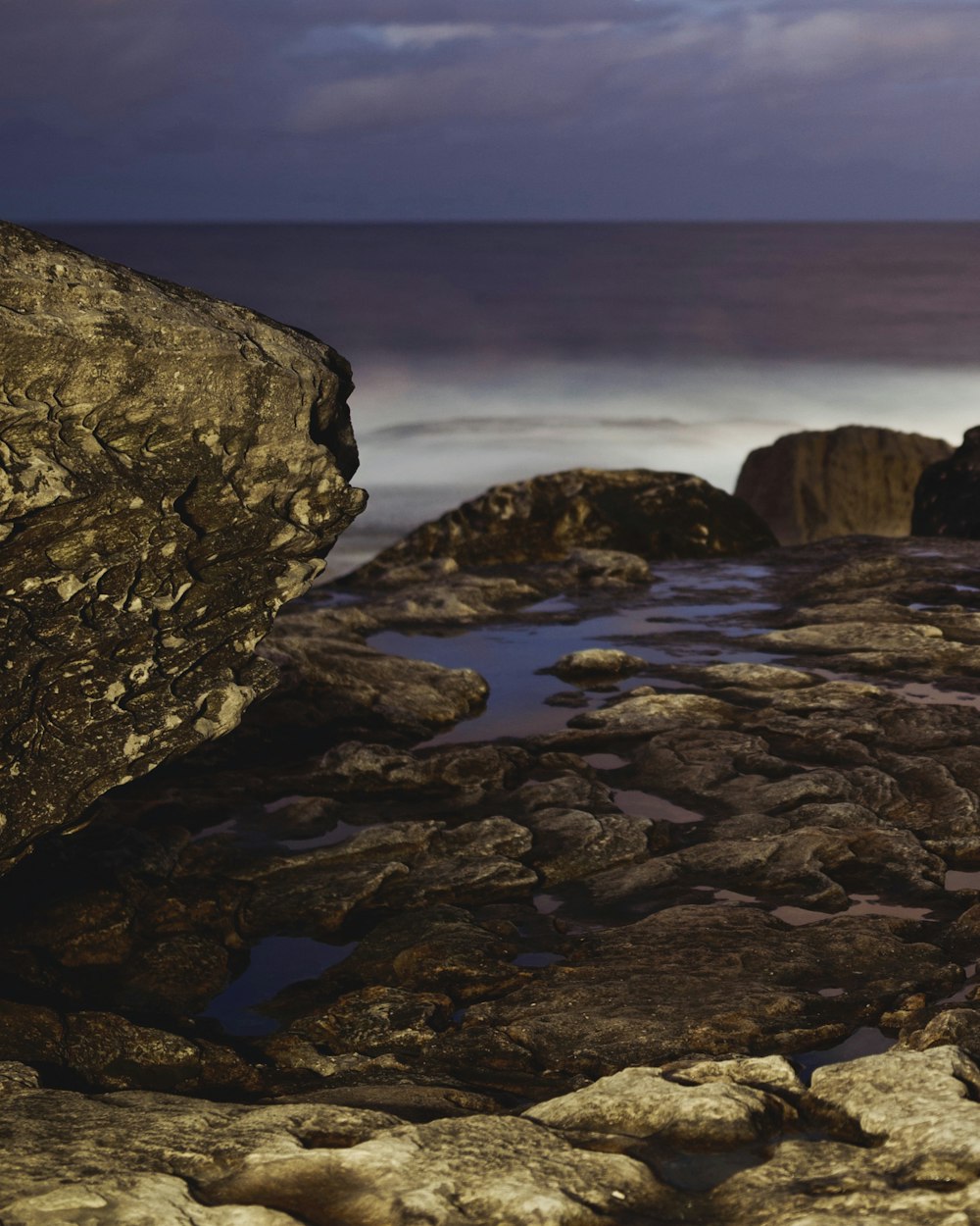 brown rock formation near body of water during daytime