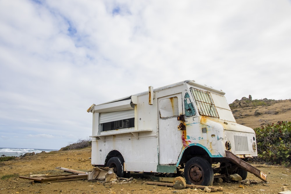 white and green van on brown sand under white clouds during daytime