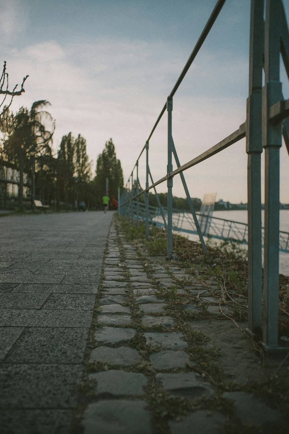 gray concrete pathway between black metal fence during daytime