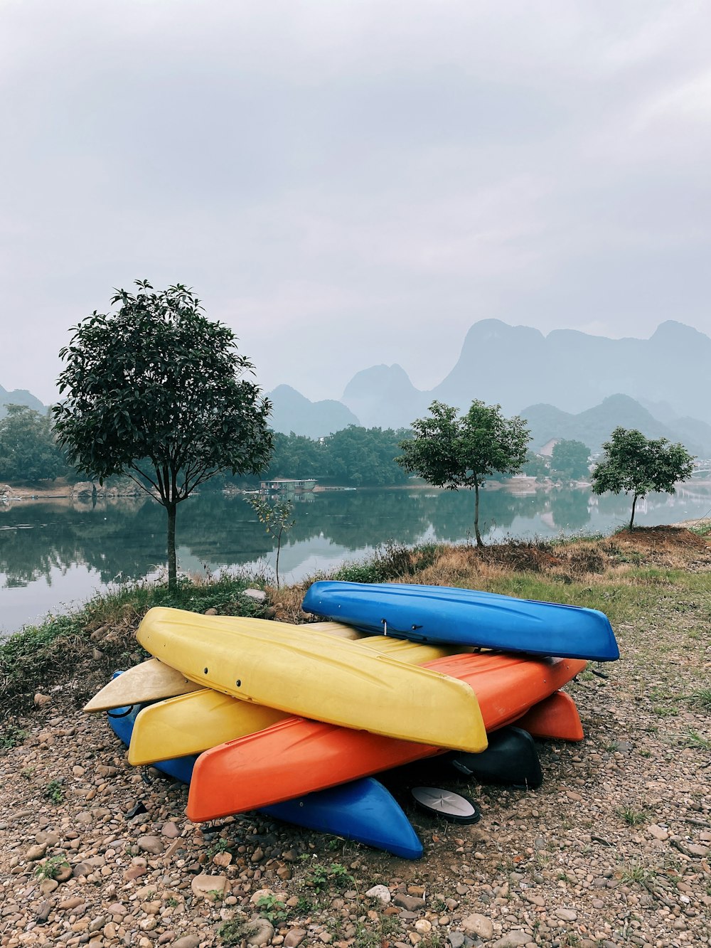 kayak jaune et orange sur un champ d’herbe verte près d’un plan d’eau pendant la journée