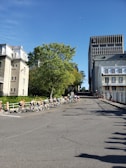 A group of diverse people riding bicycles together in an urban park.