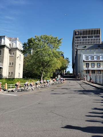 A group of diverse cyclists riding through a scenic park on different types of bicycles.