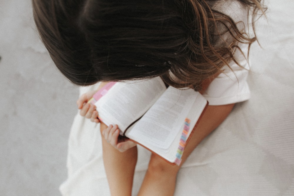 girl in white t-shirt holding white printer paper