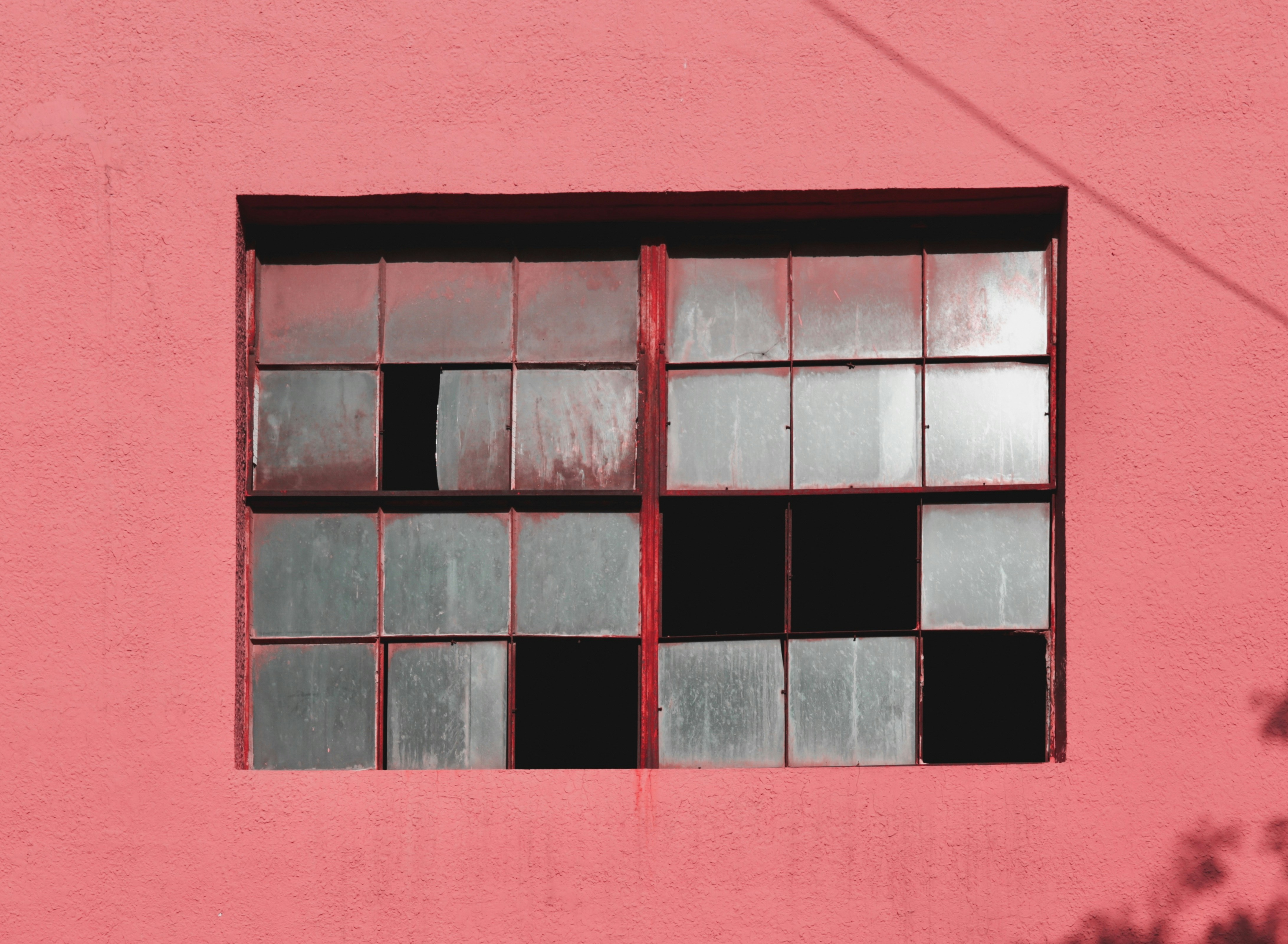 A window on a pink wall