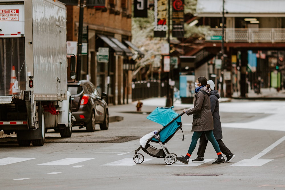 woman in gray coat walking on sidewalk during daytime