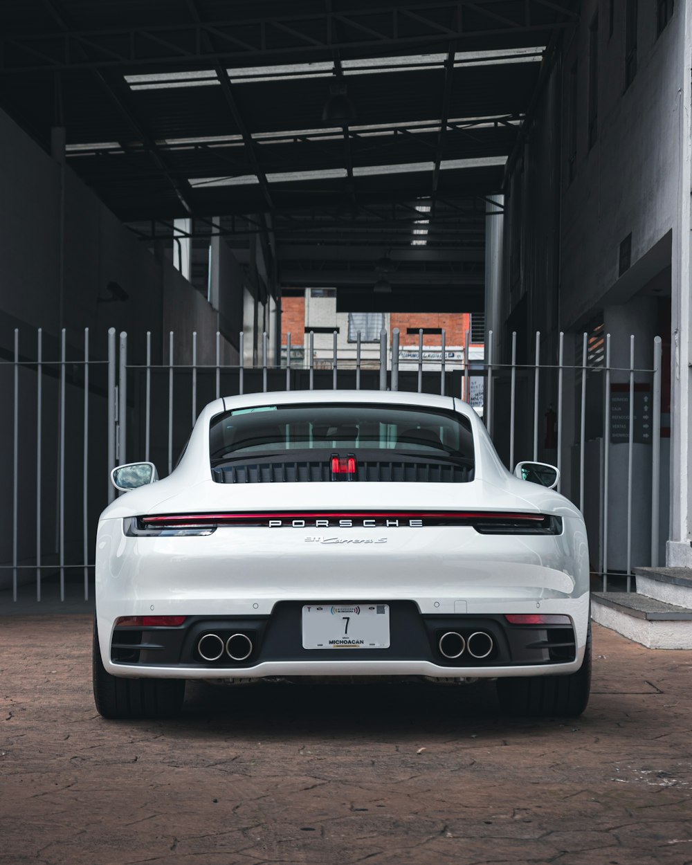 white porsche 911 parked in front of building