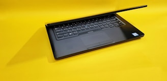 black laptop computer on yellow table
