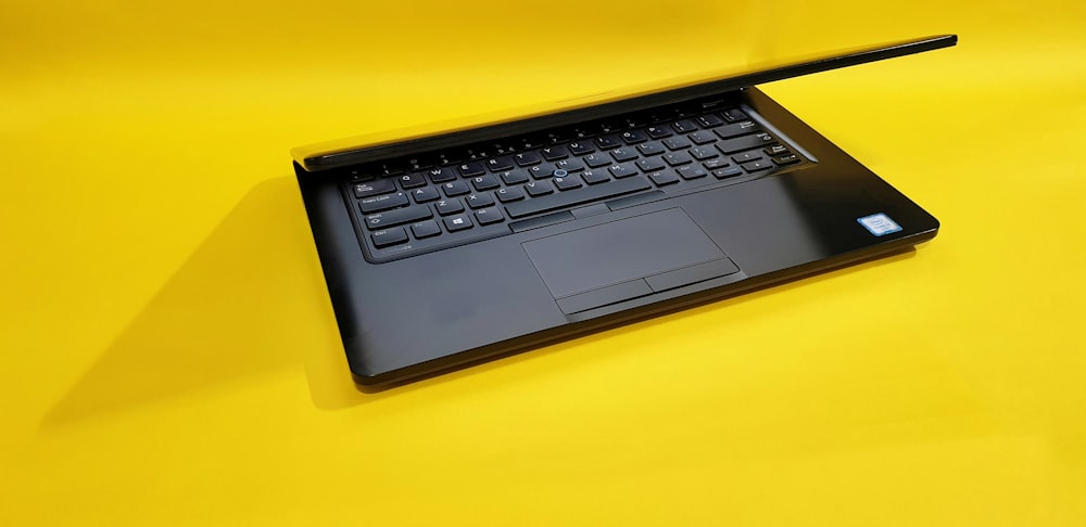 black laptop computer on yellow table