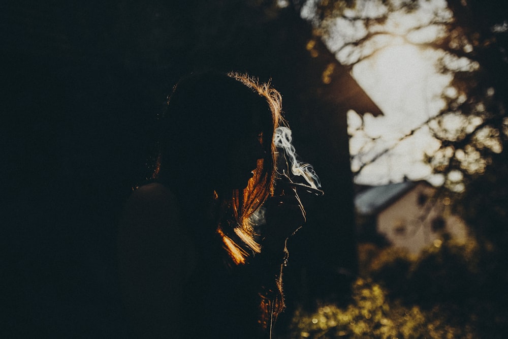 woman in black tank top standing near trees during daytime