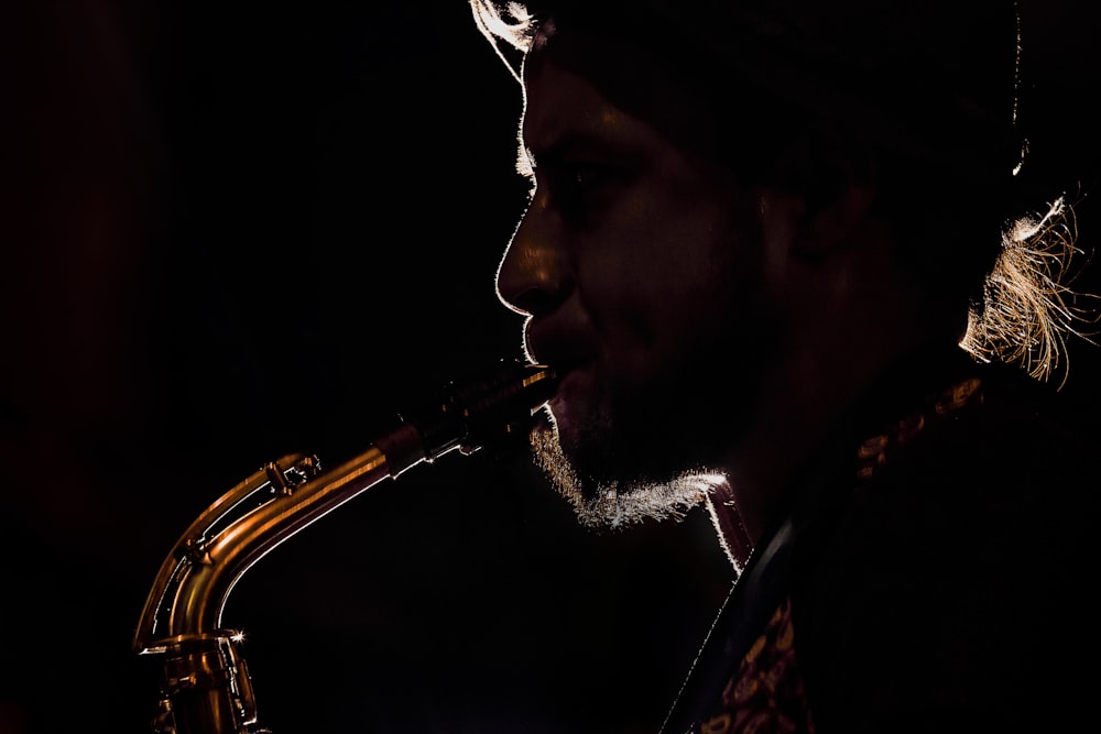 man in black suit playing saxophone