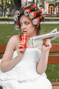 woman in white tank top holding red can