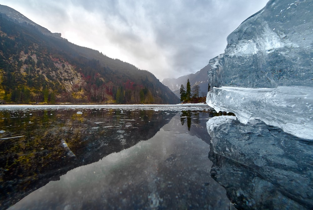 body of water near mountain during daytime