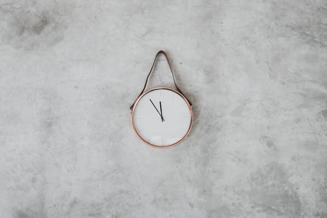 brown and white round analog wall clock