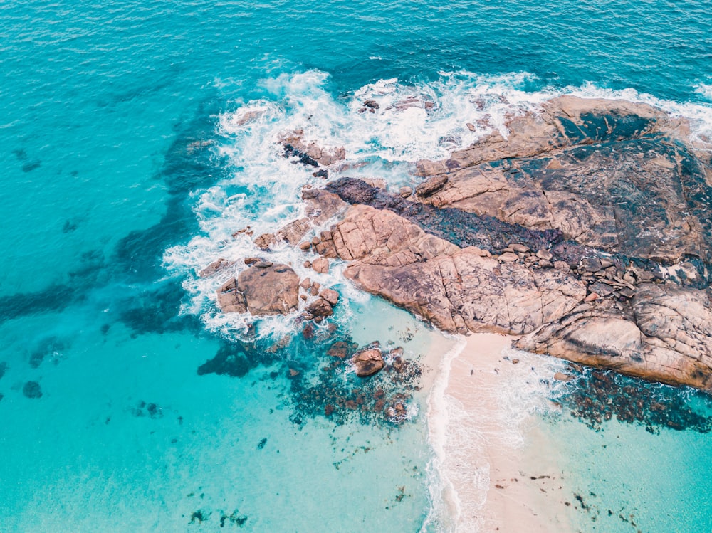 brown rock formation on blue sea water during daytime