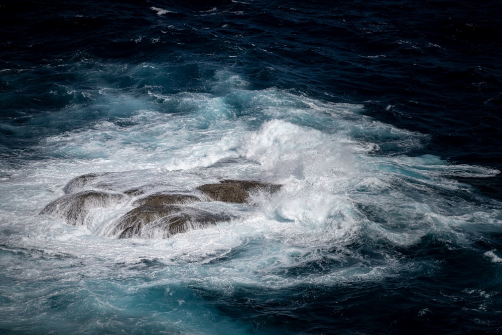 ocean waves crashing on rocks during daytime
