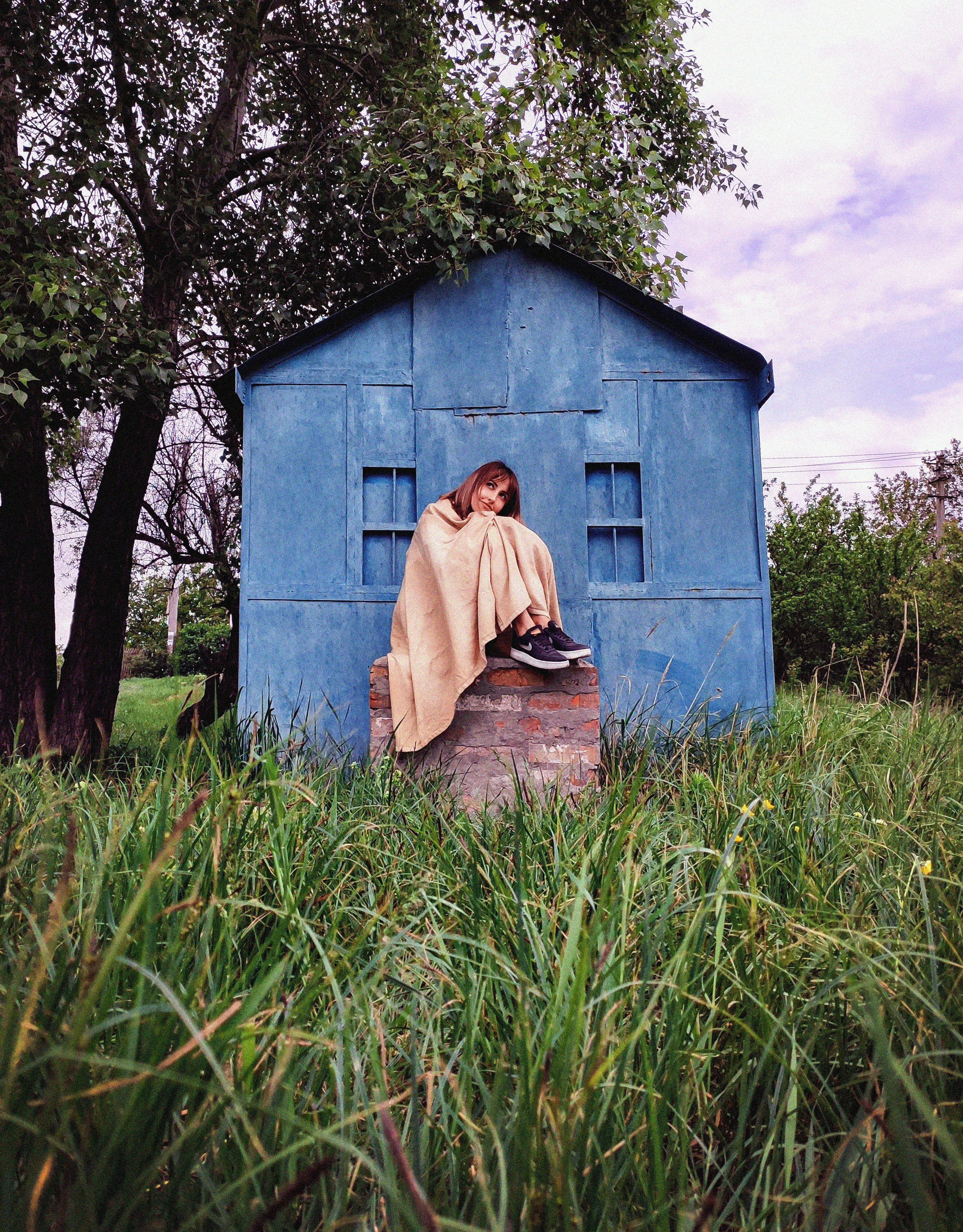 Hombre en túnica beige sentado en banco de madera marrón