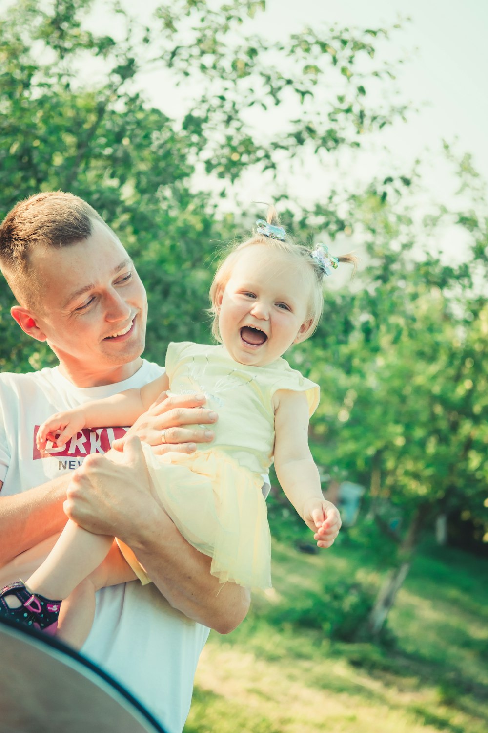 man in white crew neck t-shirt carrying girl in white t-shirt