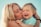 woman in teal shirt carrying girl in teal shirt