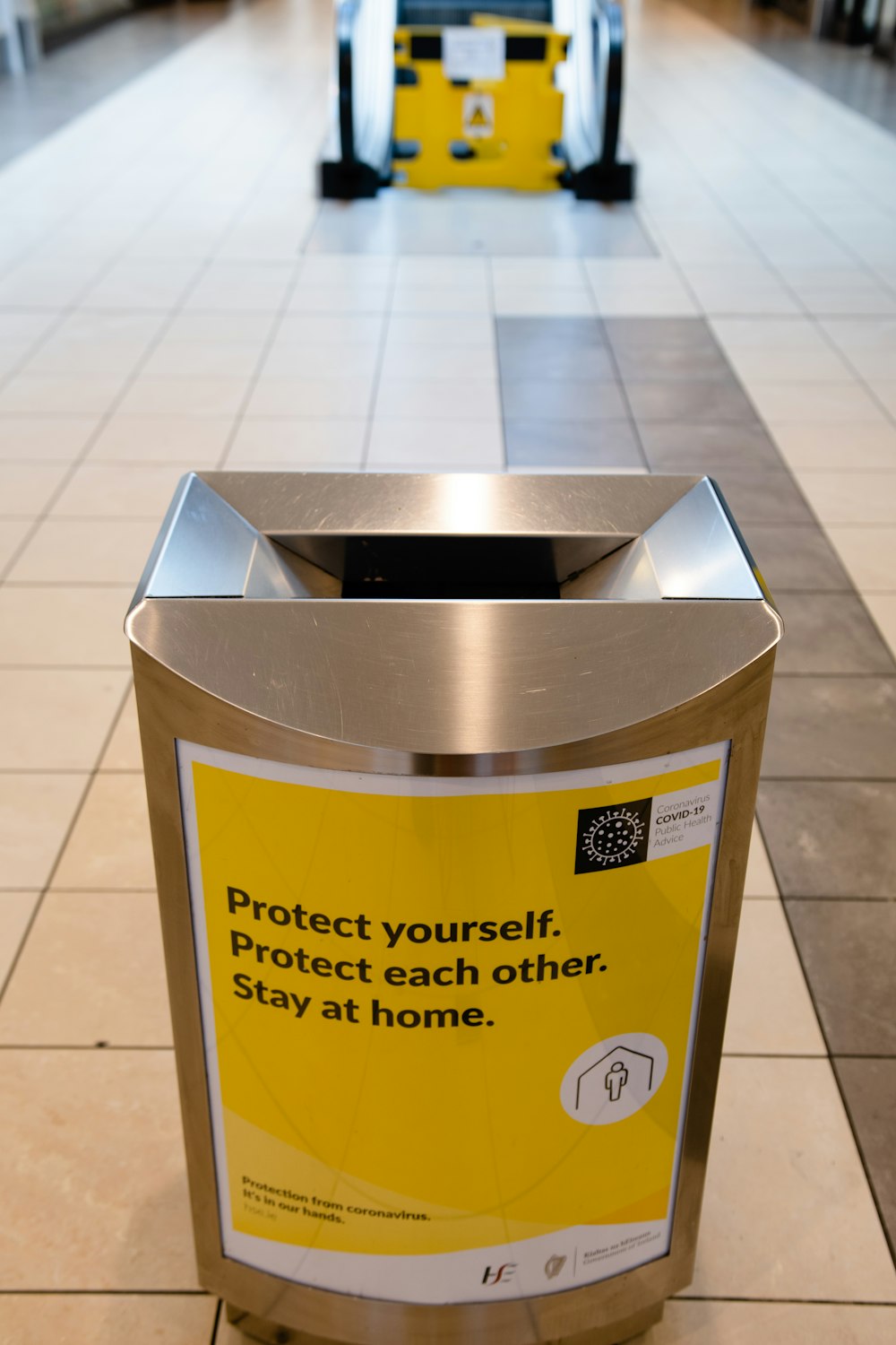 stainless steel trash bin on white ceramic floor tiles