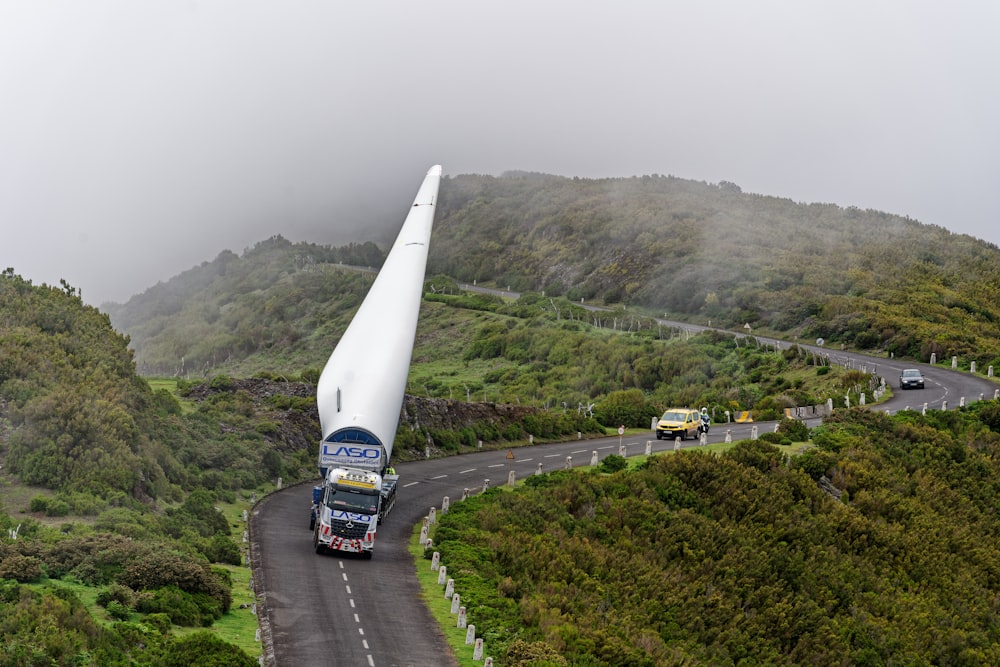 cars on road near green mountain during daytime