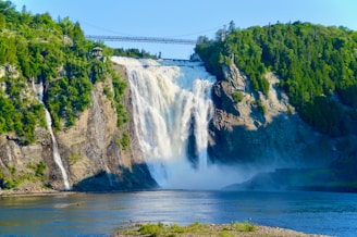 waterfalls near green trees during daytime