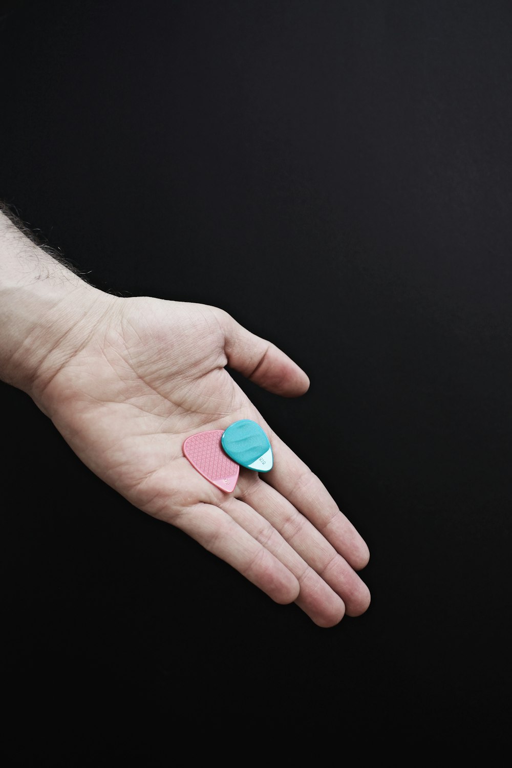 person holding blue oval medication pill