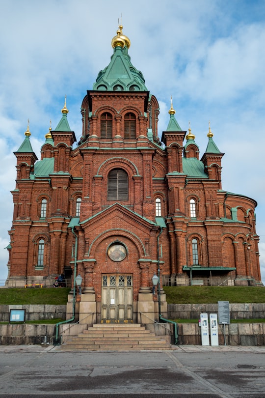 brown and green concrete building under white clouds during daytime in Uspenski Cathedral Finland