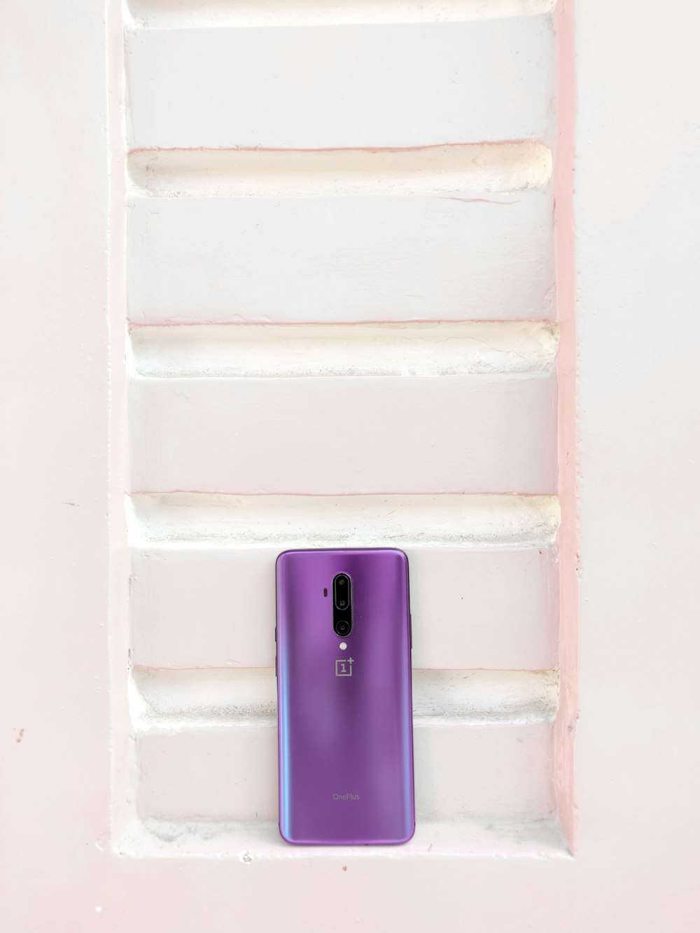 purple samsung smartphone on blue and white staircase