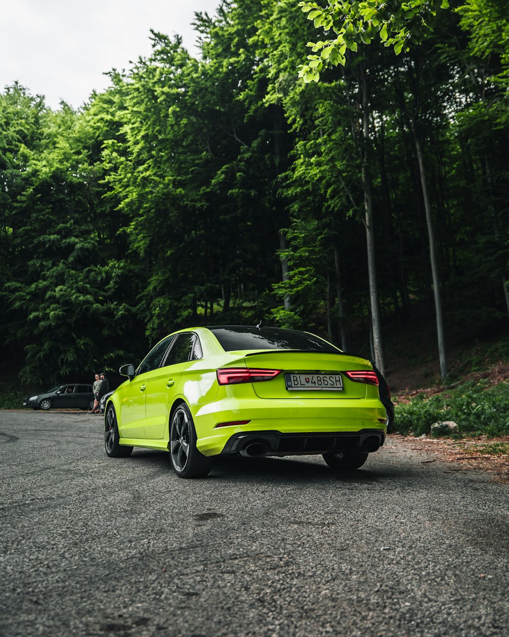 green porsche 911 parked on gray asphalt road during daytime