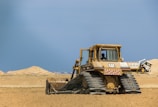red and black tractor on brown sand during daytime