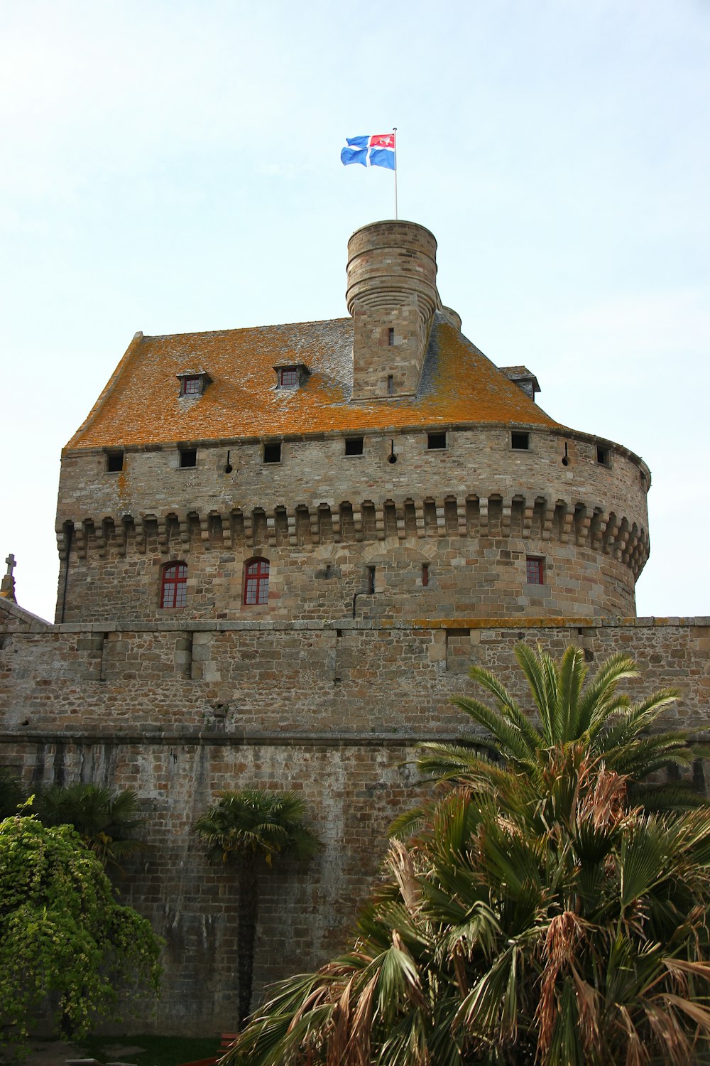 Castillo de ladrillo marrón rodeado de árboles verdes durante el día